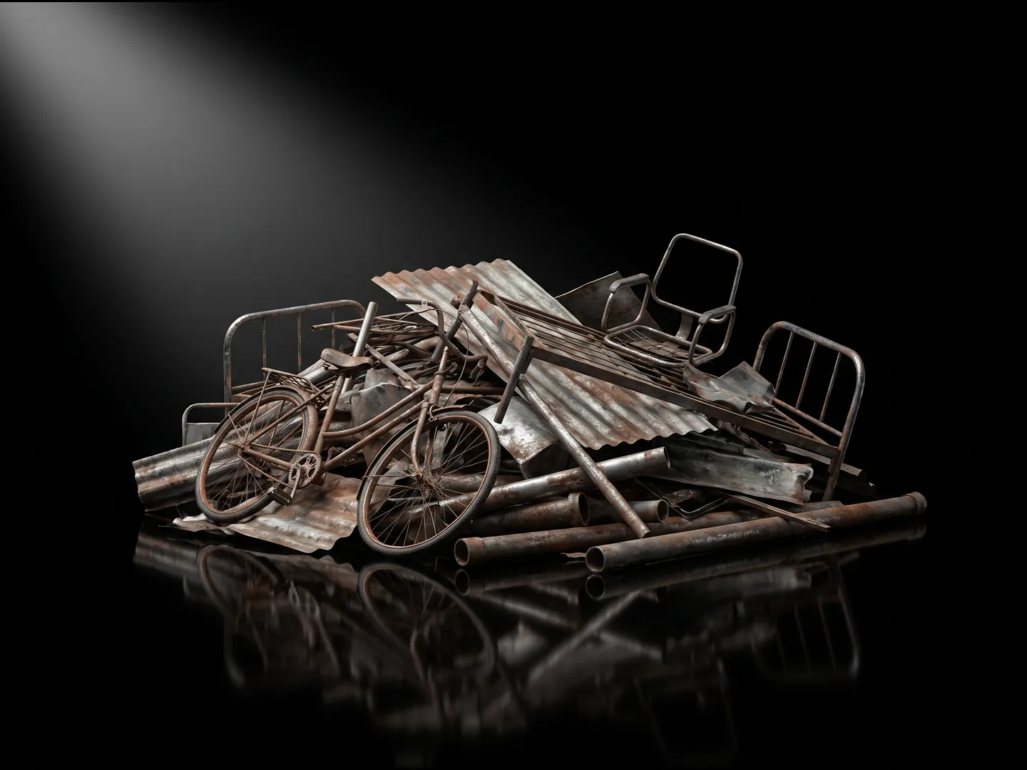 A heap of mixed scrap: a bicycle, bed frames, roofing iron and pipe